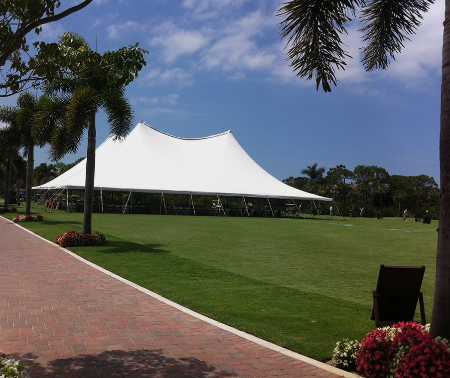 White event tent installed on a landscaped lawn for an outdoor celebration